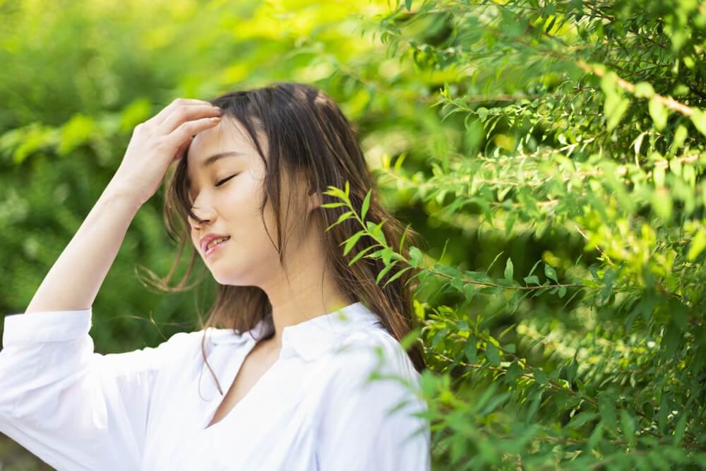 髪をかきあげる女性